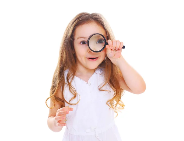 Funny little girl child looking through a magnifying glass on wh — Stock Photo, Image