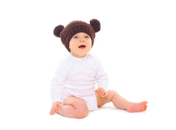 Bebê bonito em chapéu de malha marrom sentado no fundo branco — Fotografia de Stock