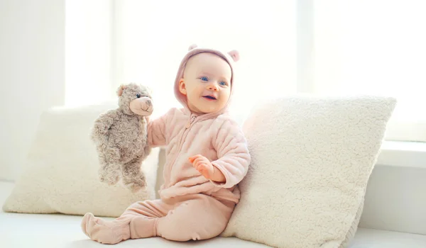 Happy cute smiling baby with teddy bear toy at home in white roo — Stock Photo, Image
