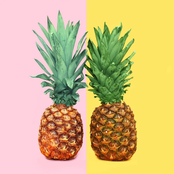 Due ananas colorati su sfondo, concetto di ananas — Foto Stock