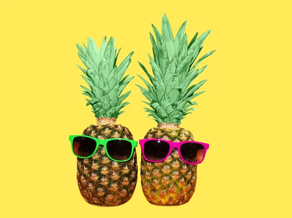Dua nanas dengan kacamata hitam pada latar belakang kuning, warna ana — Stok Foto
