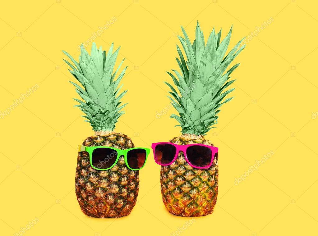 Zwei Ananas mit Sonnenbrille auf gelbem Hintergrund, bunte ana ...