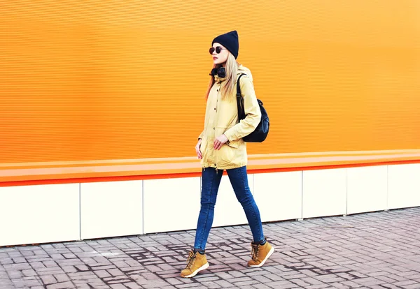 Mode jolie femme blonde marchant en ville sur orange coloré — Photo