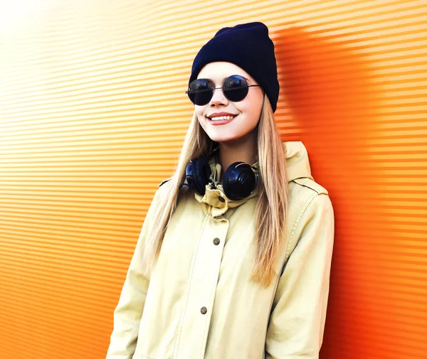 Moda menina sorridente em estilo preto com fones de ouvido escuta m — Fotografia de Stock