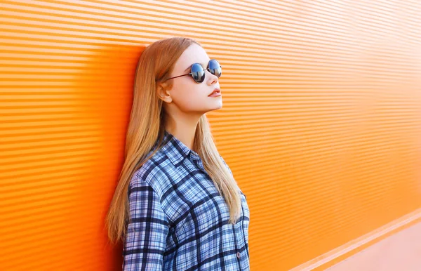 Mode hübsche blonde Frau mit Sonnenbrille über bunte orange b — Stockfoto