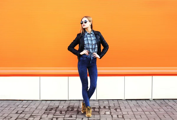 Fashion vacker kvinna klädd i svart rock stil över orange bakgrunds — Stockfoto