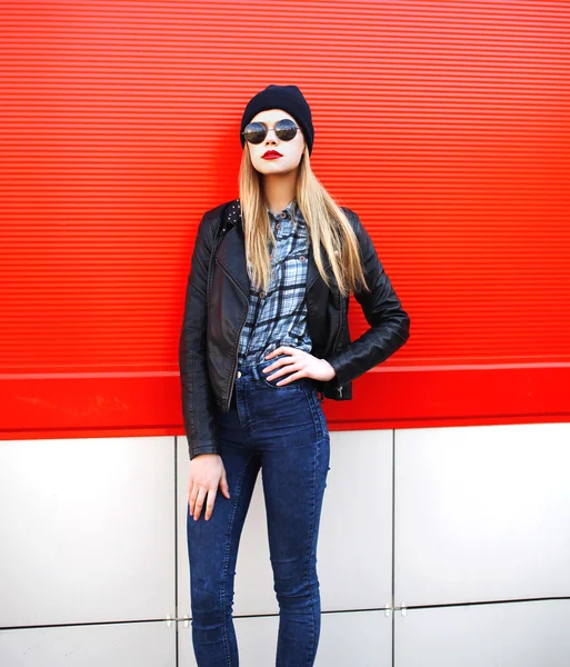 Mujer de moda en estilo rock negro sobre fondo rojo — Foto de Stock