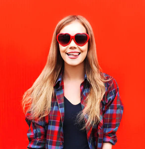 Mujer bonita en gafas de sol rojas que se divierten sobre fondos coloridos — Foto de Stock