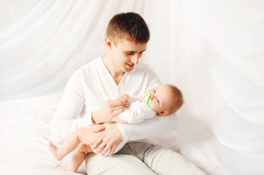 Bebekle evde yatmadan yatakta mutlu baba