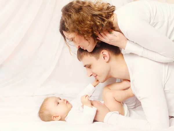 Glücklicher Vater und Mutter mit Baby zu Hause im Bett — Stockfoto