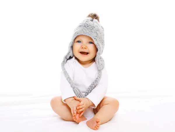 Feliz bebê sorridente em chapéu de malha cinza em um fundo branco — Fotografia de Stock
