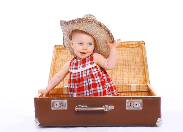 Felice bambino sorridente in cappello estivo di paglia seduto su gioco valigia — Foto Stock