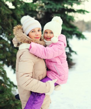 Mutlu anne sarılma çocuğun yanında kış günü Noel ağacı