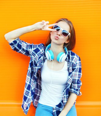 Serin kız eğleniyor müzik kulaklık üzerinde renkli b dinler.