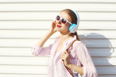Mutlu gülümseyen kadın müzik kulaklık üzerinde beyaz ba dinler
