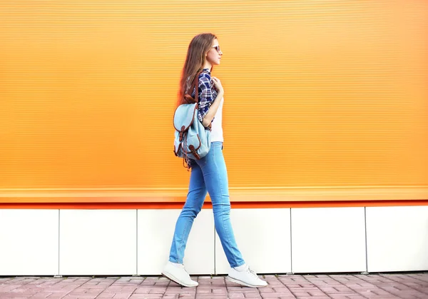 Fashion woman walking in city over colorful orange background — Stock Photo, Image