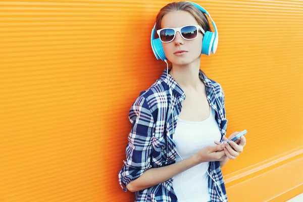 Menina em fones de ouvido ouve música usando smartphone sobre colorf — Fotografia de Stock