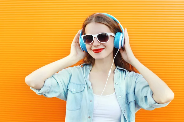 Mulher feliz ouve e gosta de música em fones de ouvido mais colorido — Fotografia de Stock