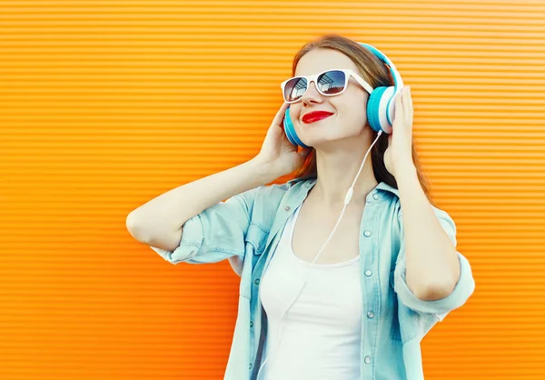 Ευτυχισμένος νεαρή γυναίκα να ακούει και να απολαμβάνει τη μουσική στα ακουστικά μέσω co — Φωτογραφία Αρχείου