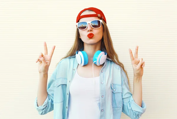 Jolie femme cool dans les lunettes de soleil et casquette rouge s'amuser sur whit — Photo