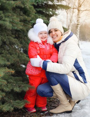 Anne ve çocuğun yanında Noel ağacı kış günü gülümseyen mutlu