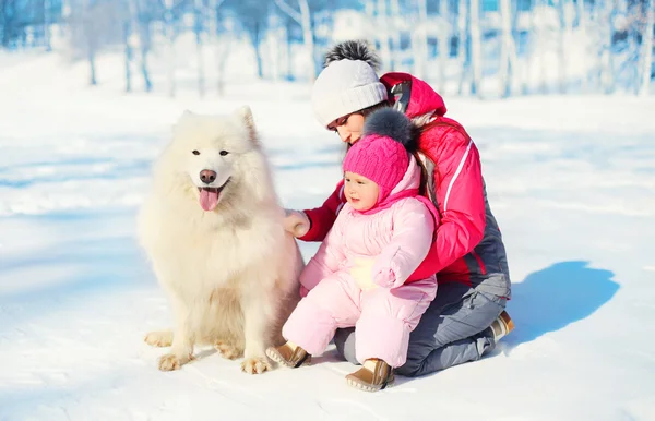 Mother and baby with white Samoyed dog together on snow in winte — Stock Photo, Image