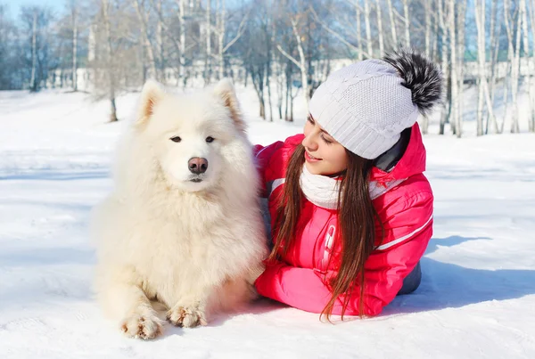 Portrait woman owner with white Samoyed dog lying on snow in win — Stock Photo, Image