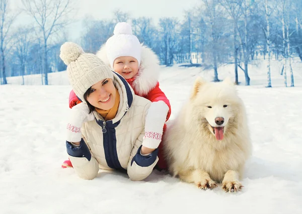 Mãe e bebê com cão branco Samoyed juntos na neve em winte — Fotografia de Stock