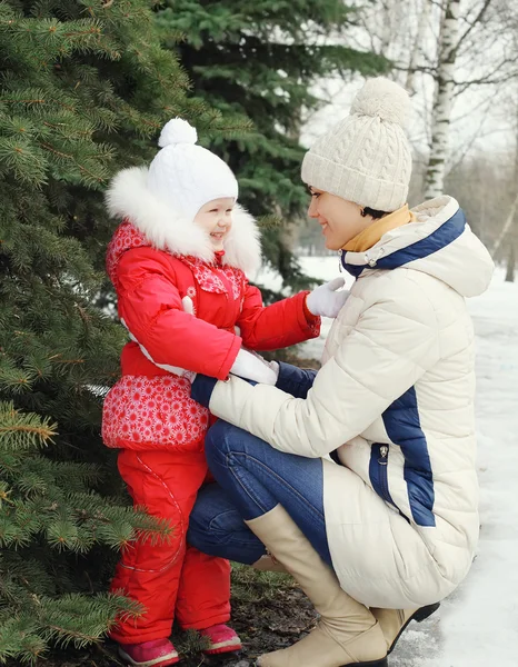 Mor och barn nära julgran i vinterdag — Stockfoto