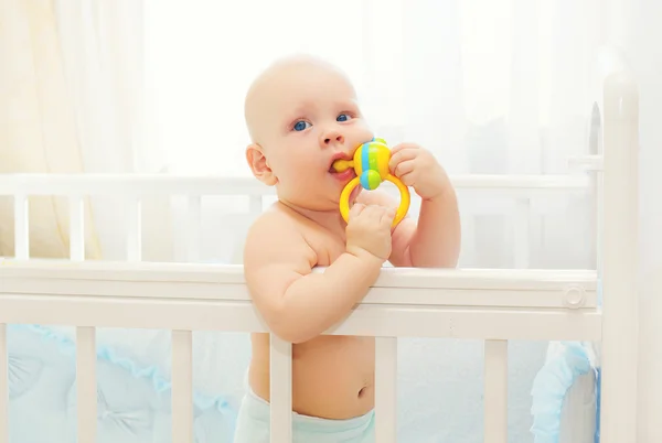 Kleines Baby spielt auf dem Bett nach Hause mit Spielzeug — Stockfoto