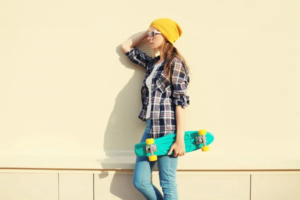 Mode hübsches Mädchen trägt eine bunte Kleidung mit Skateboard o — Stockfoto