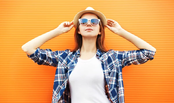 Fashion woman wearing a straw hat and sunglasses over orange bac — Stock Photo, Image