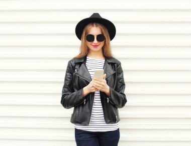 Moda güzel kadın Smartphone siyah rock tarzında w üzerinde kullanarak.