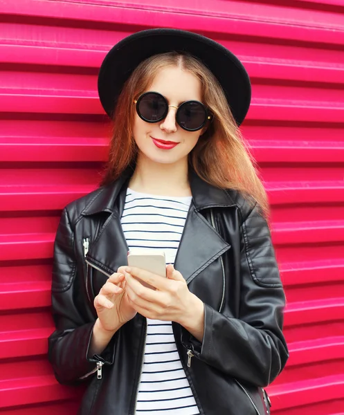 Fashion pretty woman using smartphone in rock black style over c — Stock Photo, Image