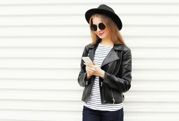 Mulher bonita usando smartphone em estilo rock preto sobre bac branco — Fotografia de Stock