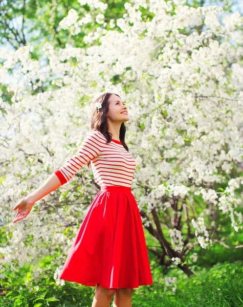 Mulher jovem feliz bonita desfrutando cheiro em uma primavera florida — Fotografia de Stock