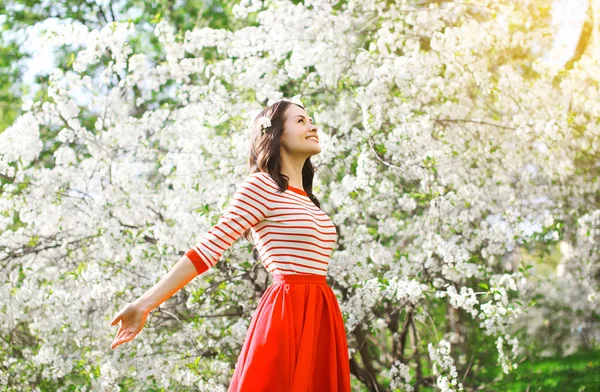 Mulher feliz bonita desfrutando cheiro em uma garde primavera floração — Fotografia de Stock