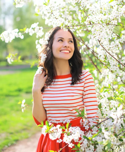 Gelukkig mooi lachende vrouw in bloeiende lentetuin — Stockfoto