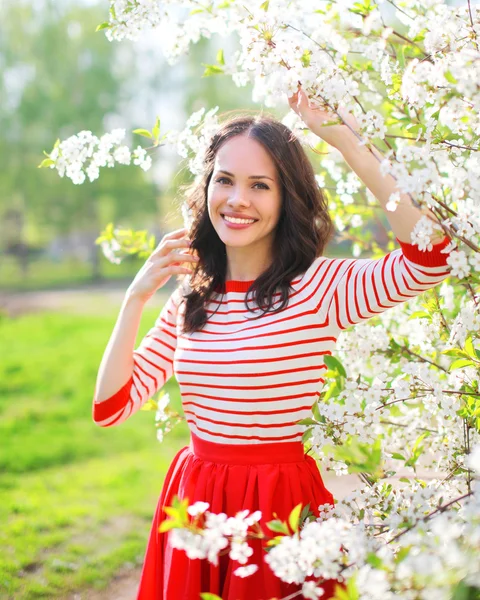 Portrait beautiful smiling woman in flowering spring garden — Stock Photo, Image