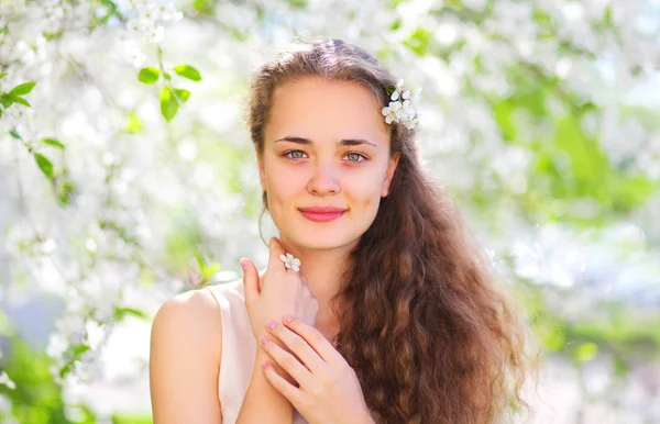 Spring portrait of beautiful young girl with curly hair in flowe — Stock Photo, Image