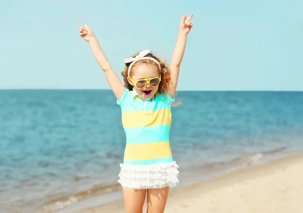 Mutlu küçük kız çocuğu eğleniyor sahilde deniz üzerinde — Stok fotoğraf