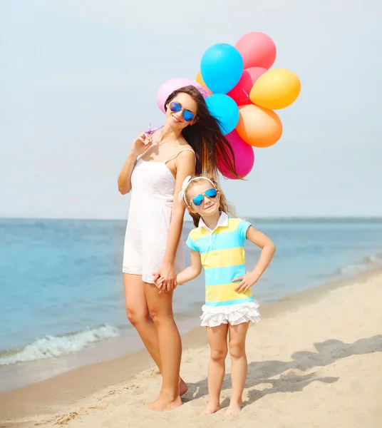 Feliz madre e hijo con globos de colores caminando juntos o —  Fotos de Stock