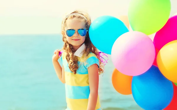 Portrait of happy smiling child on summer beach with colorful ba — Stock Photo, Image