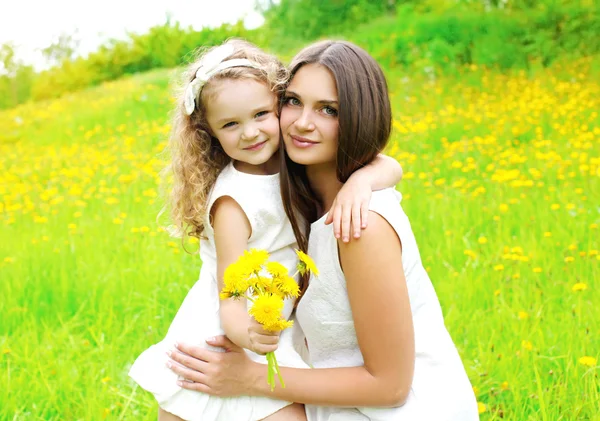 Ευτυχισμένη μητέρα και το παιδί της κόρης του, μαζί με το κίτρινο πικραλίδα f — Φωτογραφία Αρχείου