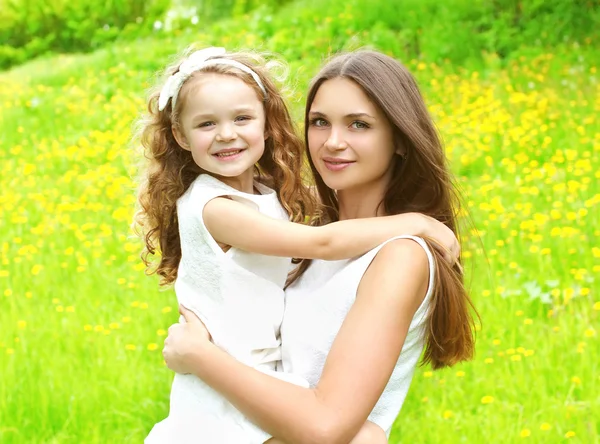 Happy mother and daughter child hugging in summer day — Stock Photo, Image