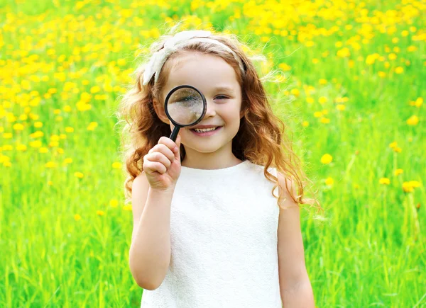 Porträt kleines Mädchen blickt durch Lupe auf Sommer — Stockfoto