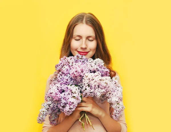 Feliz mujer sonriente disfrutando del olor de flores de ramo de lila sobre — Foto de Stock