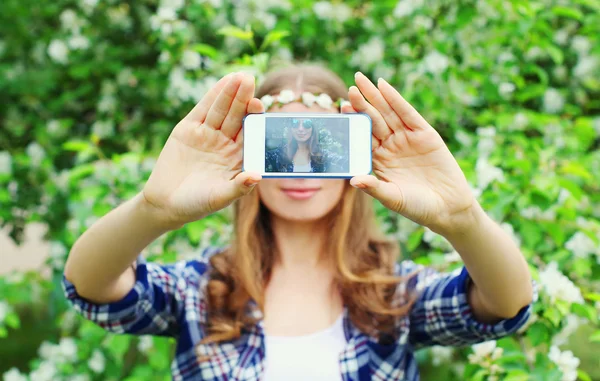 Mujer hace autorretrato en la vista del teléfono inteligente de la pantalla en primavera — Foto de Stock