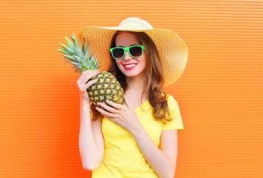 Güneş gözlüğü ve şapka ile ananas c üzerinde oldukça gülümseyen kadın