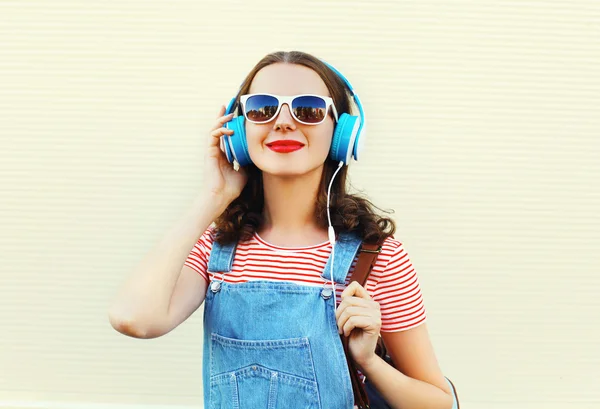 Felice donna ascolta la musica in cuffie su sfondo bianco — Foto Stock